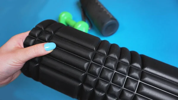 Foam Roller Gym Fitness Equipment Blue background self Myofascial Release - MFR. Hand holds a roller. How to choose equipment for sports — Stock Image Foam Roller Gym Fitness Equipment Blue Background Self Myofascial Release Stock Image