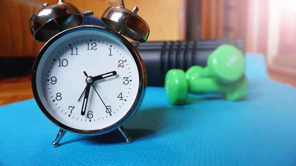 Esterilla de yoga azul, dos mancuernas, despertador, rollo de automasaje - tiempo para el deporte — Foto de Stock