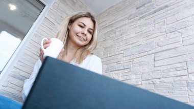 Yan görünümü. Bir fincan kahve ve defter ile genç iş kadını.