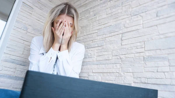 Mujer mira a su portátil con una expresión de preocupación dolorida — Foto de Stock