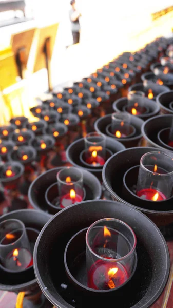 Burning big red candles in Buddhist temple — Stock Photo, Image