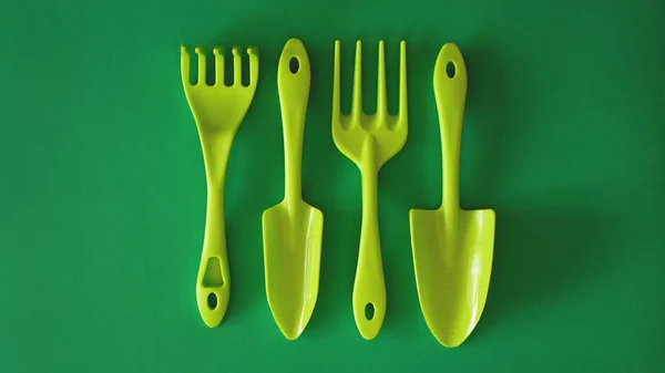 Set von grünen Gartenwerkzeugen auf grünem Hintergrund — Stockfoto