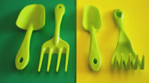 Set grüner Gartengeräte auf grünem und gelbem Hintergrund — Stockfoto