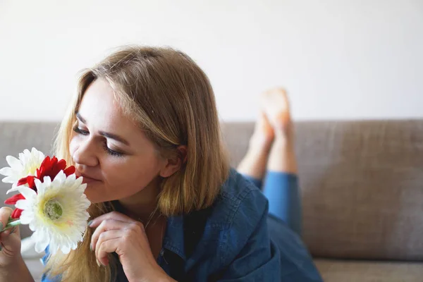 Atraente jovem mulher cheirando buquê de flores — Fotografia de Stock