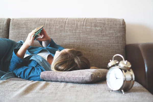 Giovane donna che utilizza il telefono a letto, guardando schermo, insonnia, controllare l'ora — Foto Stock