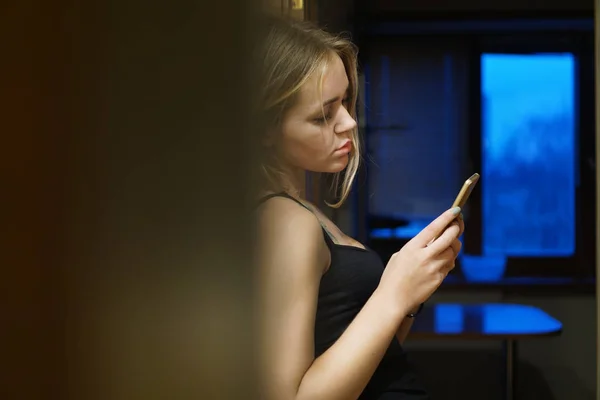 Giovane donna europea detiene telefono moderno, vestito con abiti casual — Foto Stock