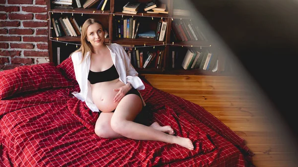 Красивая молодая стильная беременная женщина в черном белье и белой рубашке, лофт — стоковое фото