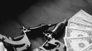 Siyah bir arka plan ve dolar dövme makineleri. Dövme sanat konsepti