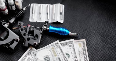 Siyah bir arka plan ve dolar dövme makineleri. Dövme sanat konsepti