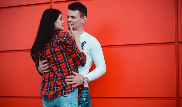 Couple sortir ensemble et embrasser en amour dans une journée ensoleillée - fond rouge — Photo