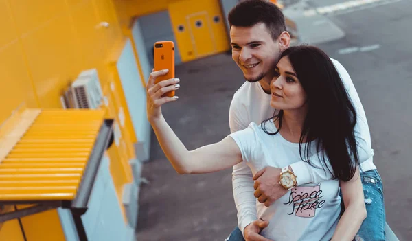 Young lovely couple making selfie on smartphone over yellow background — 스톡 사진