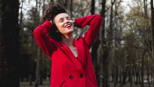 Glamorous woman wearing red outfit and matching red lip gloss.