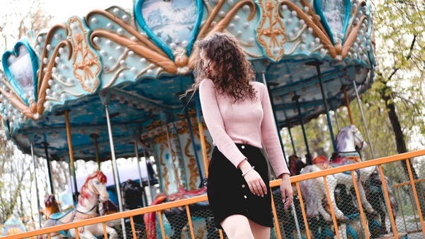 Girl chilling in amusement park in weekend morning. Laughing female model