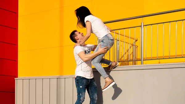 Feliz hombre llevando a su novia sobre fondo amarillo — Foto de Stock