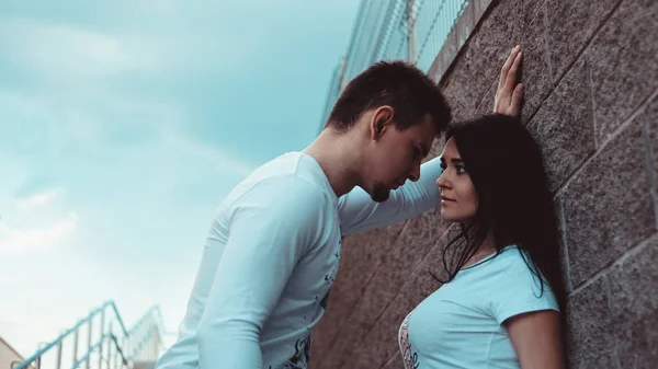 Young loving couples standing next to the brick wall, happy and satisfied — Stock Photo, Image