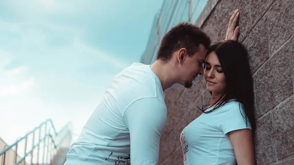 Junge Liebespaare, die glücklich und zufrieden an der Mauer stehen — Stockfoto