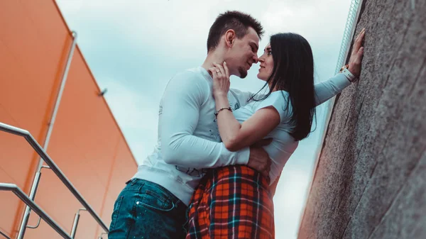 Jóvenes parejas amorosas de pie junto a la pared de ladrillo, felices y satisfechos — Foto de Stock