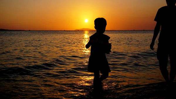 Vater und Kind spielen am Strand bei Sonnenuntergang. Konzept der Familie — Stockfoto