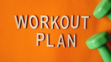 Fitness konsepti, egzersiz planı. Turuncu arka planda yeşil halterler. Üstte görüntü
