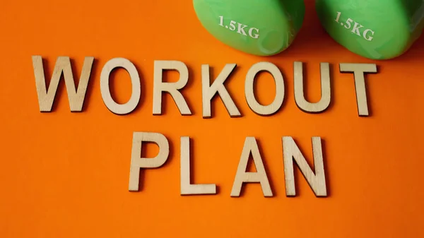 Concepto de fitness, plan de entrenamiento. Mancuernas verdes sobre fondo naranja. Vista superior — Foto de Stock