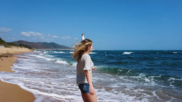 На пляже под солнечным светом одетая и одурманенная девушка — стоковое фото