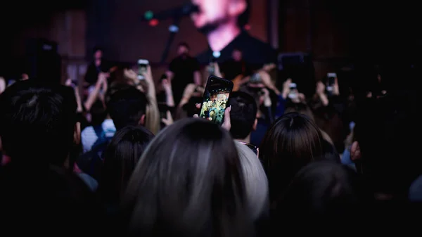 Personnes prenant des photos avec téléphone intelligent tactile lors d'un concert de musique — Photo
