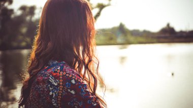 Nehrin yakınındaki doğada dinlenen kadının arkası