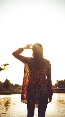 Nehrin yakınındaki doğada dinlenen kadının arkası