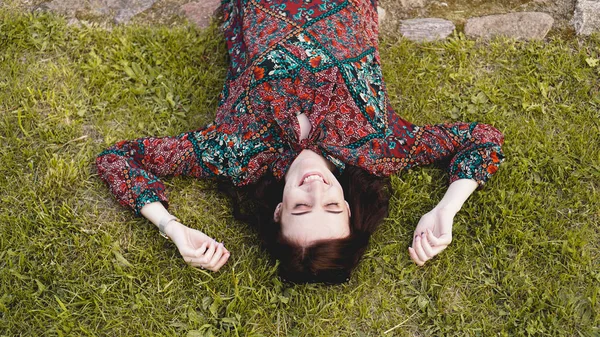 Mujer joven acostada en la hierba. Gente relajándose al aire libre . — Foto de Stock