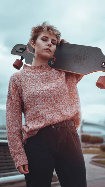 Portret van jonge vrouwelijke skateboarder holding haar skateboard — Stockfoto