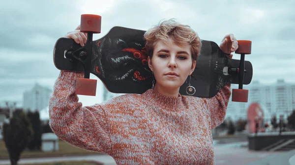 Retrato de una joven patinadora sosteniendo su monopatín —  Fotos de Stock