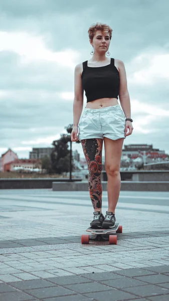 Menina bonita com tatuagens com longboard — Fotografia de Stock