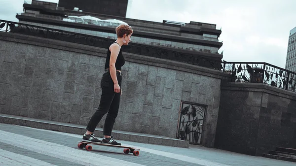 Jovem mulher desportiva montando no longboard — Fotografia de Stock