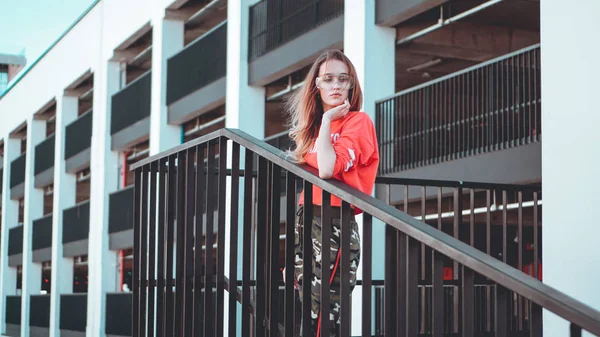 Modelmodel trägt roten Kapuzenpulli mit Aufschrift los angeles posiert auf Parkplatz — Stockfoto