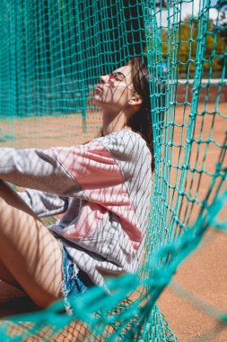 Şık modern kadın yaz aylarında bir spor sahasında bir fotoğraf için poz