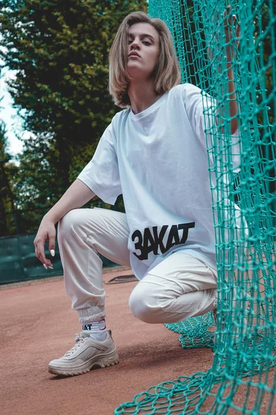 La mujer de estilo moderno posa para la foto en el campo deportivo en verano —  Fotos de Stock