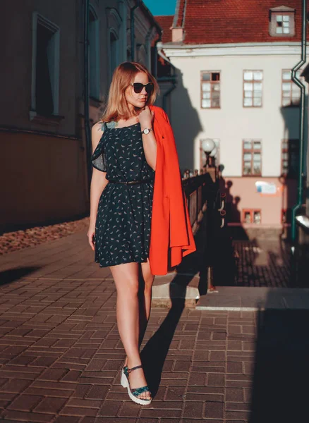 街の通りの都市の背景に赤いジャケットのかなり若い女性 — ストック写真