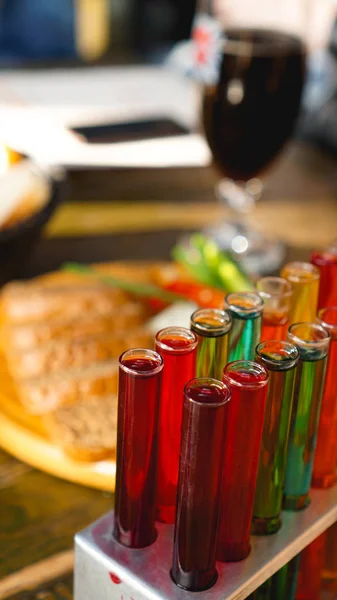 Reagenzgläser mit farbiger Flüssigkeit. Alkohol im Reagenzglas dunkle Bar — Stockfoto