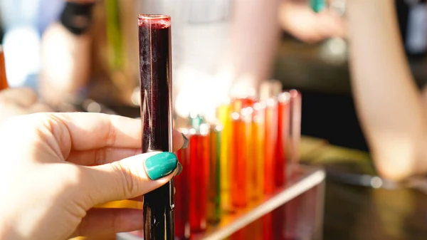 Tubos de ensayo con líquido multicolor. Alcohol en tubos de ensayo barra oscura —  Fotos de Stock