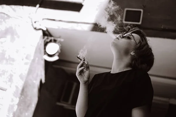 Fille millénaire aux cheveux courts et lunettes de soleil miroir fumer cigarette — Photo