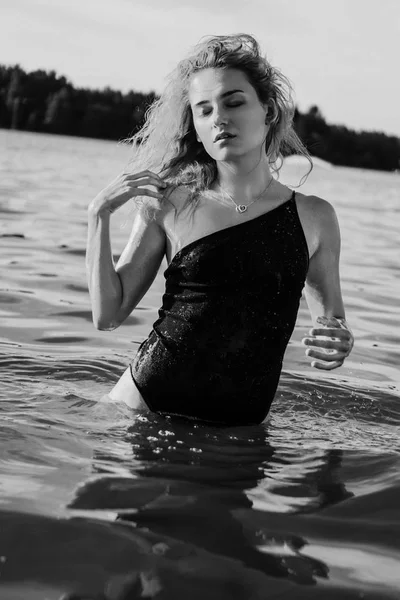 Μια νεαρή όμορφη γυναίκα στέκεται στο νερό.. — Φωτογραφία Αρχείου