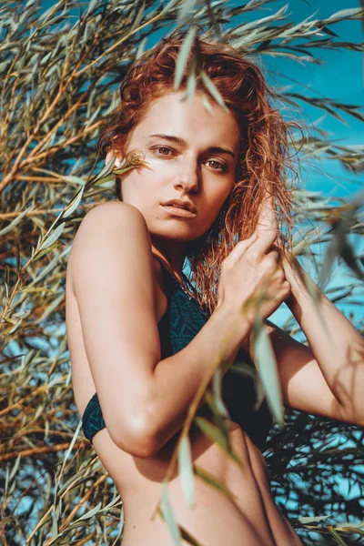 Kvinna i bikini på en tropisk strand med växter — Stockfoto