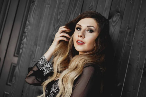 Jovem mulher bonita, vestindo transparente vestido de noite preto peignoir no quarto escuro — Fotografia de Stock