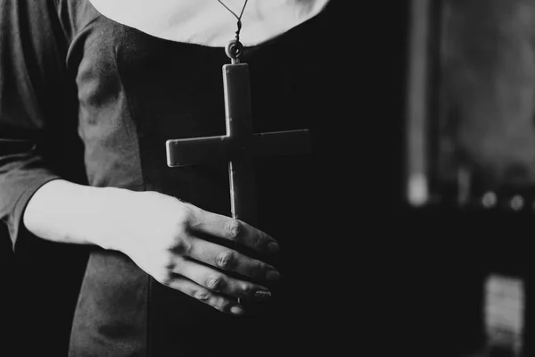 Люди и религия, сестра-католик, молящаяся в церкви, держа крест в руках — стоковое фото