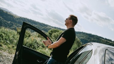 Dağ manzarasında duran bir adamın arka görünümü. Gezgin manzaranın tadını çıkarıyor