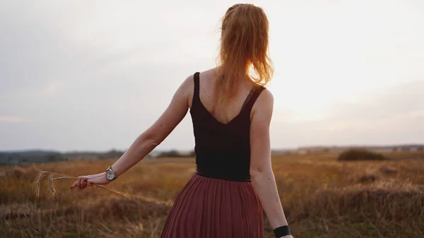 Mujer joven disfrutando de la naturaleza y la luz del sol en el campo de paja — Foto de Stock