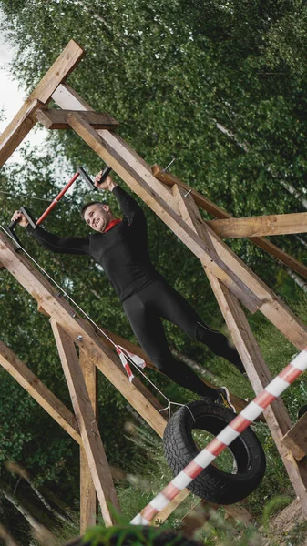 Hombre pasando por obstáculos durante la carrera de obstáculos en el campo de entrenamiento — Foto de Stock