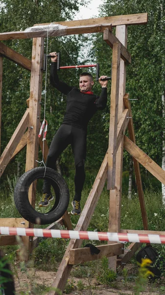 Homem que passa por obstáculos durante o percurso de obstáculos no campo de treino — Fotografia de Stock