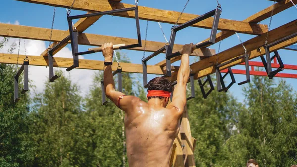 Hombre pasando por obstáculos durante la carrera de obstáculos en el campo de entrenamiento — Foto de Stock