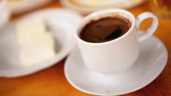 A cup of coffee in a white cup on wooden background — Stock Photo, Image